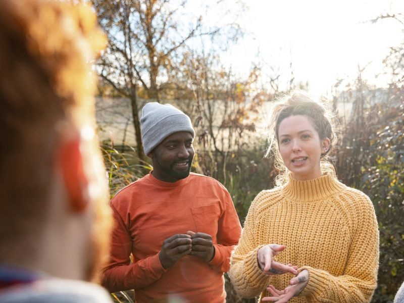 People having a  discussion as part of a community tree planting effort.